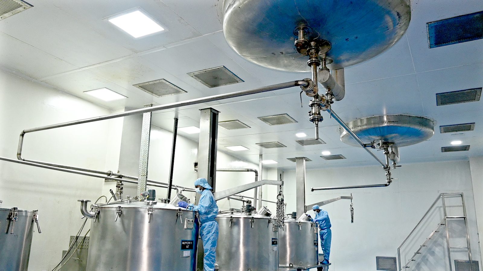 Operators working across a row of blending vessels