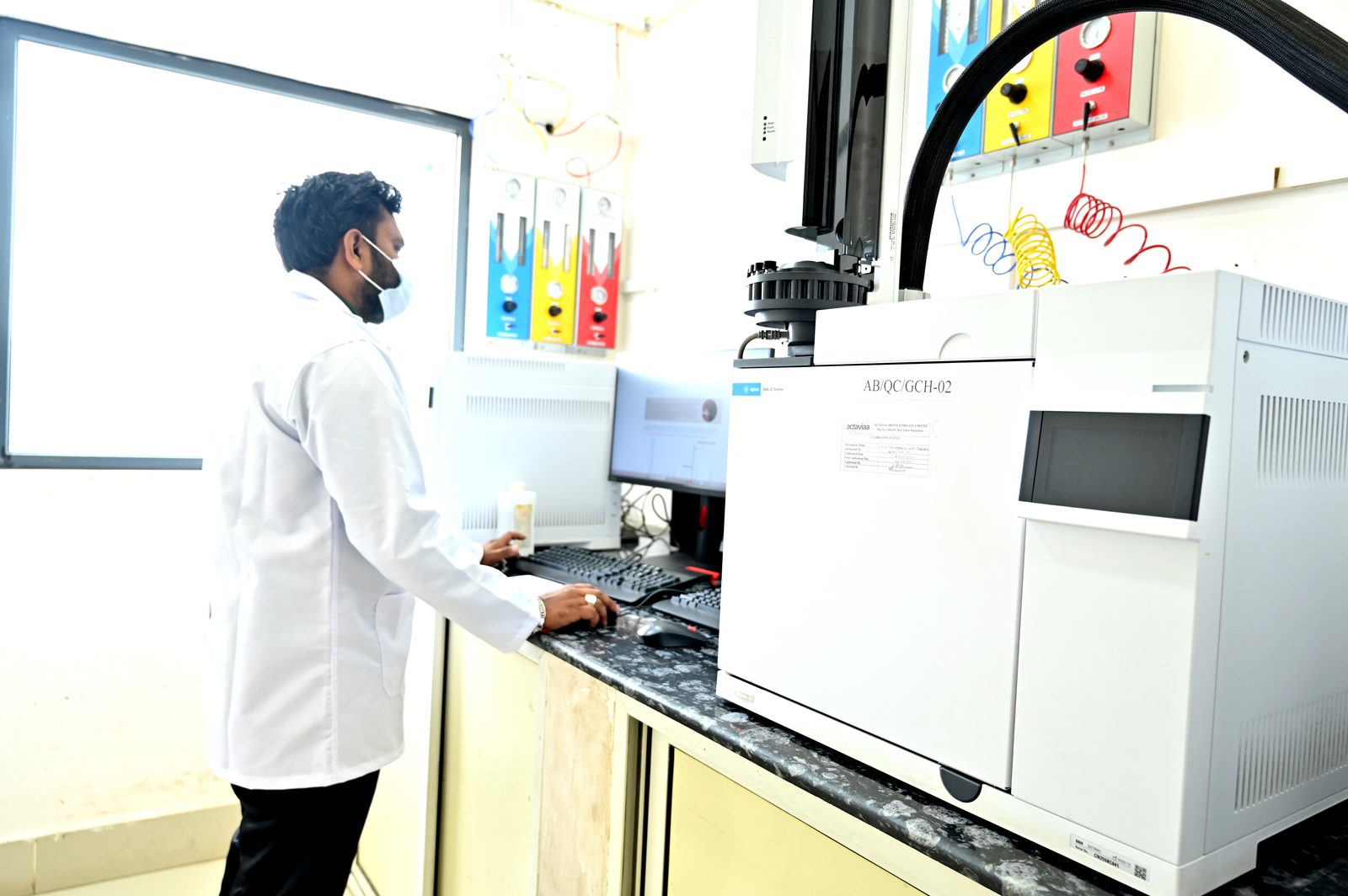 Analyst operating a gas chromatograph in the QC lab