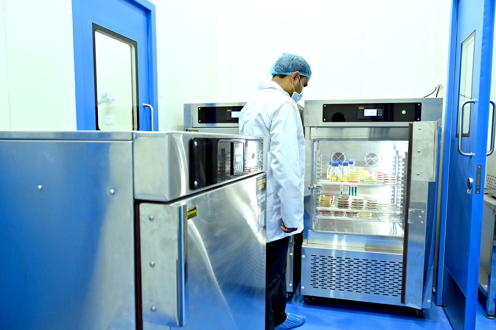 Analyst checking microbiology samples in an incubator